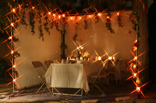 View into a sukkah with a set table and lots of light.